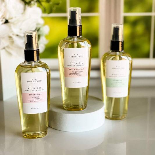 Simply Stated Spring Floral Orchard Body Oil collection featuring Magnolia + Peony, Peach Nectar + Prosecco, and Verbena + Lemon scents.