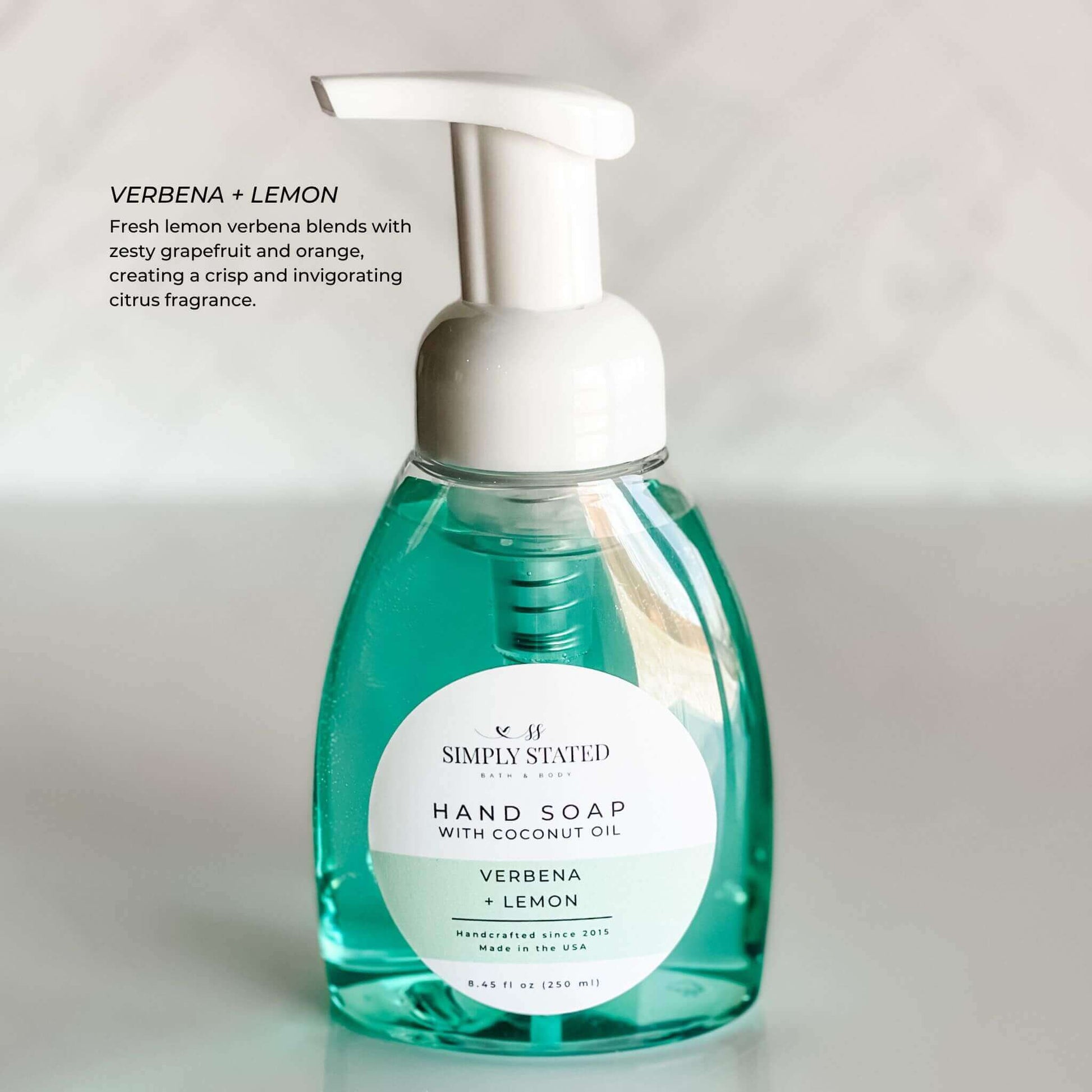 Vibrant green-tinted bottle of Verbena + Lemon Hand Soap, offering a refreshing citrus burst with lemon verbena and grapefruit.