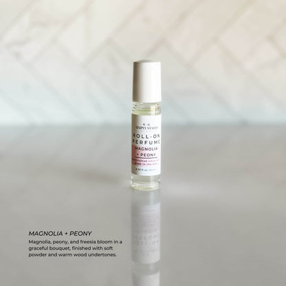 A single bottle of Magnolia + Peony Roll-On Perfume with clean, elegant packaging displayed on a neutral background.