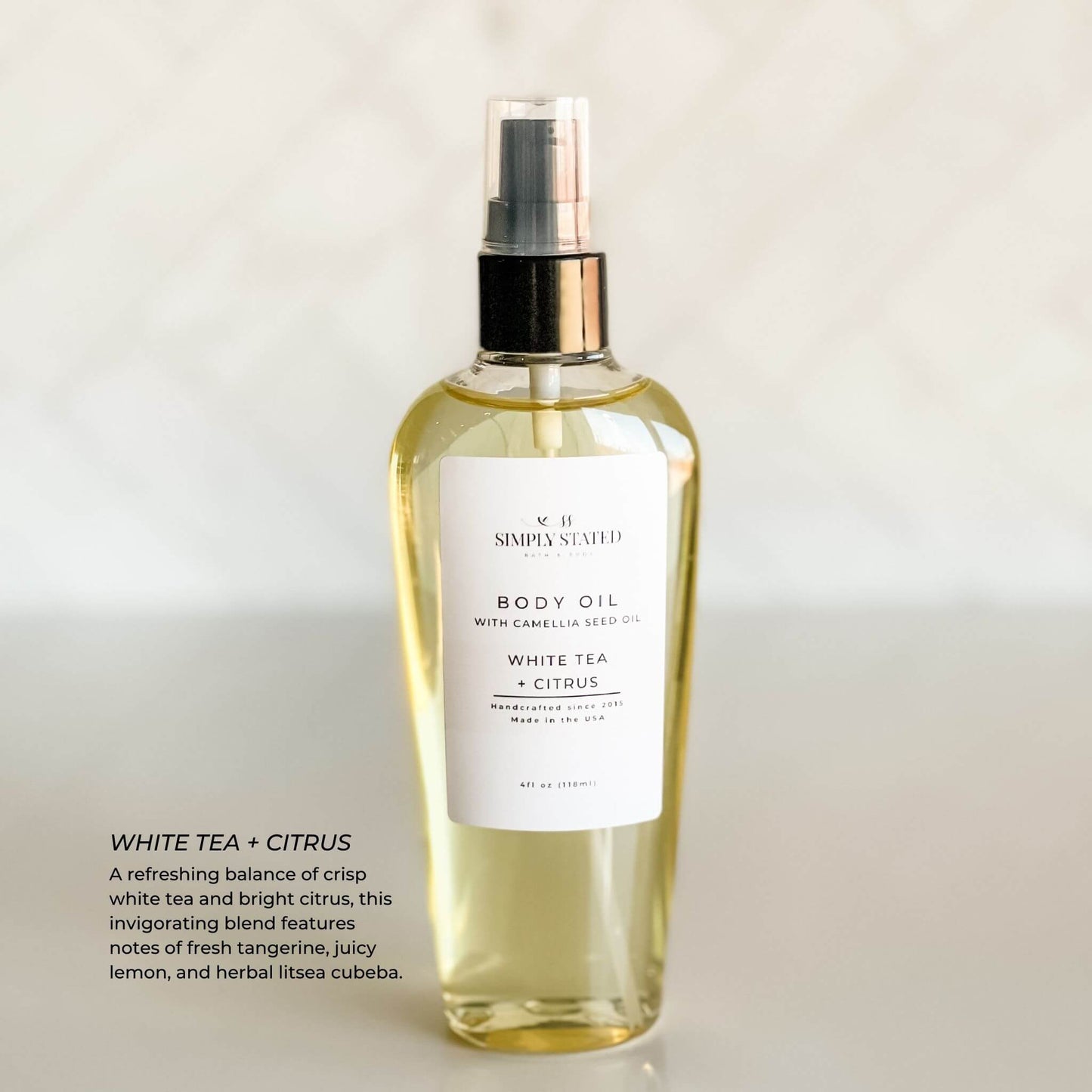 Simply Stated Bath & Body White Tea + Citrus Body Oil bottle with camellia seed oil and minimalist white label. A refreshing citrus scent featuring white tea, tangerine, juicy lemon, and herbal litsea cubeba. Perfect for light summer hydration.