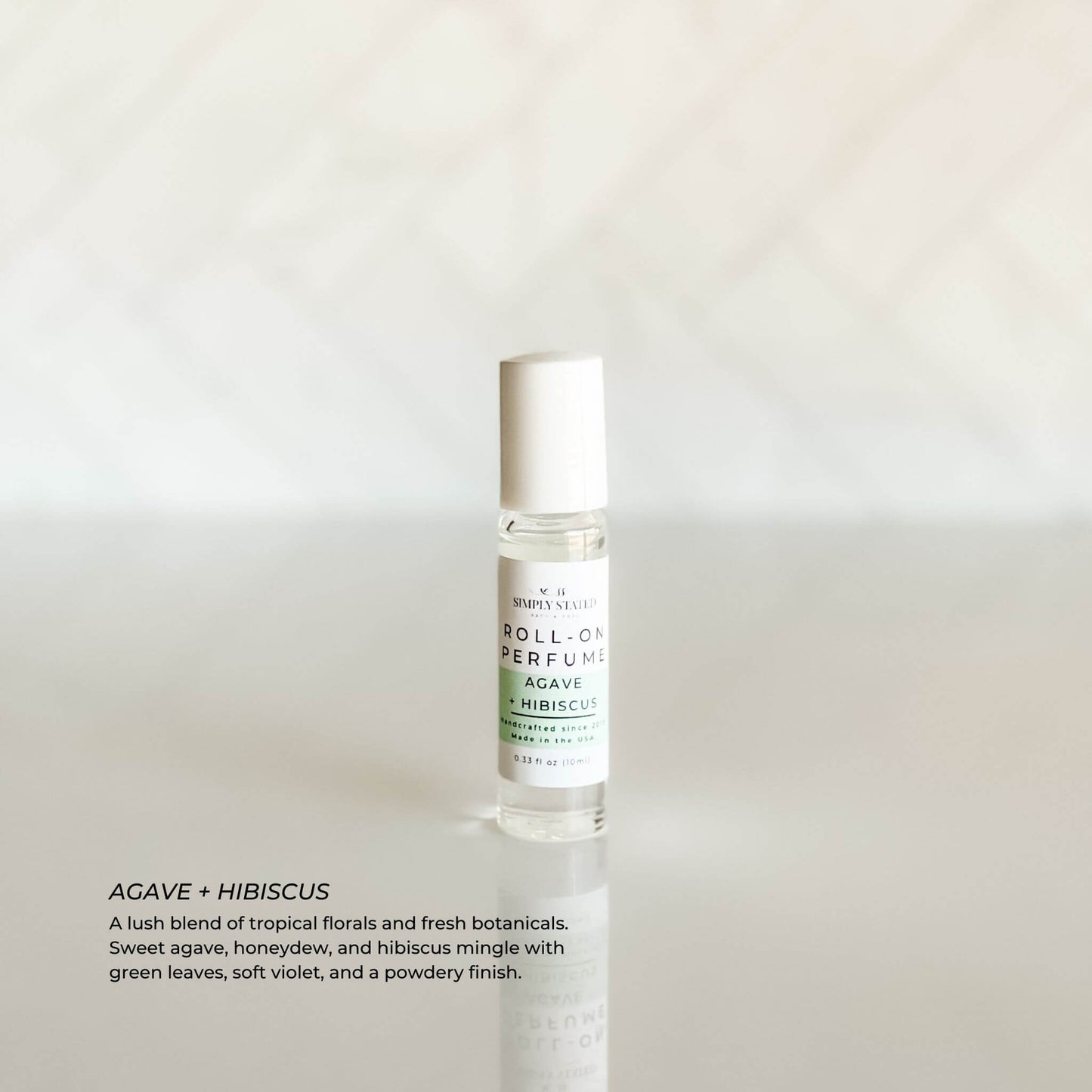Simply Stated Roll-On Perfume in Agave + Hibiscus – tropical fragrance blend with agave, honeydew, hibiscus, and soft violet in a 10ml glass bottle.