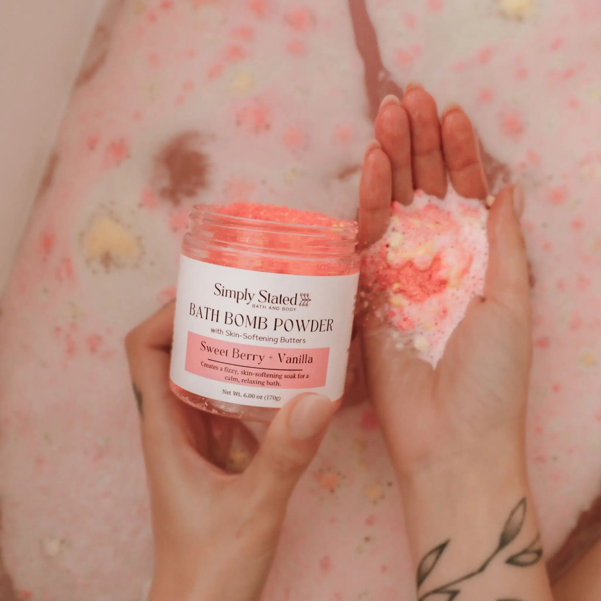 Sweet Berry + Vanilla Bath Bomb Powder jar held in hand with pink powder scooped in other palm