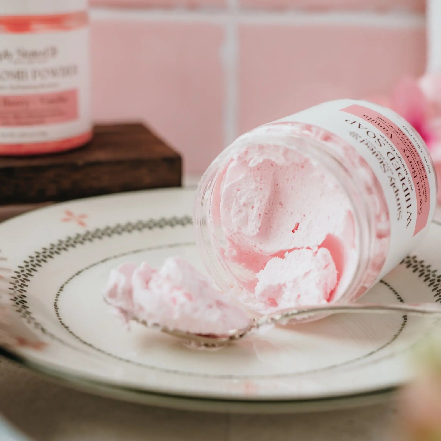 Close-up of Sweet Berry + Vanilla whipped soap texture lifted from the jar on a spoon, showing its fluffy, creamy consistency