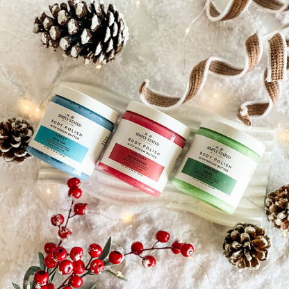 Simply Stated Body Polish trio with kokum butter, snowy holiday scene with pinecones, berries, and twinkle lights.