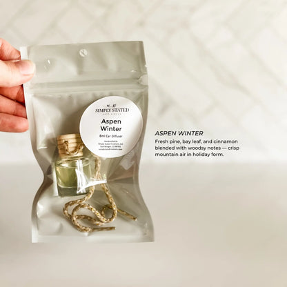 Car diffuser packaging labeled 'Aspen Winter' held by a hand on a light background