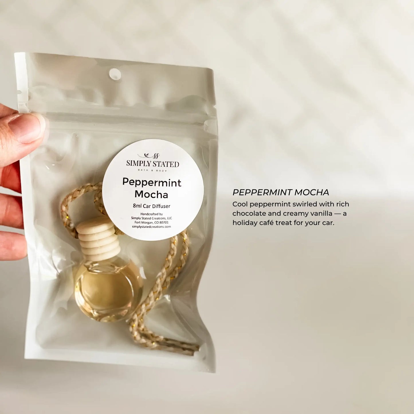 Peppermint Mocha car diffuser packaging held by a hand on a light background