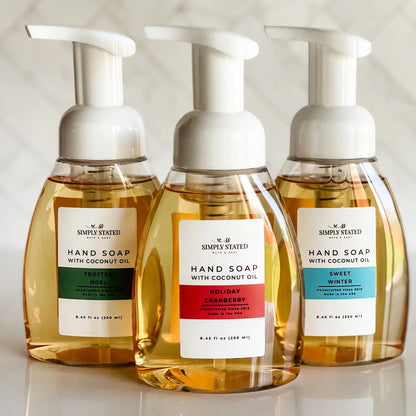 Simply Stated Foaming Hand Soap trio with coconut oil, Frosted Noel, Holiday Cranberry, and Sweet Winter pump bottles.