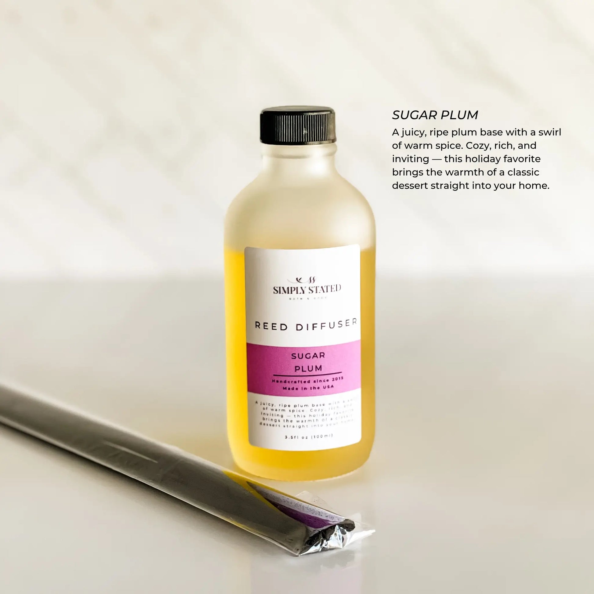 Reed diffuser bottle labeled 'Sugar Plum' on a light background