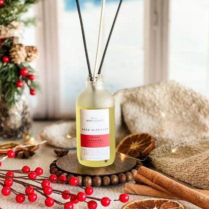 Reed diffuser bottle with festive decorations on a table