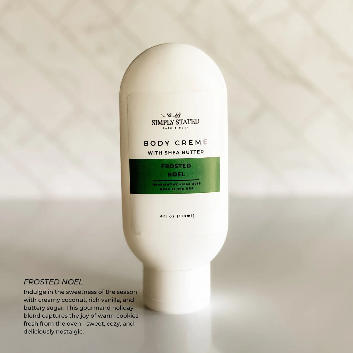 Simply Stated Frosted Noel Body Creme with shea butter, coconut vanilla holiday scent, on marble background.