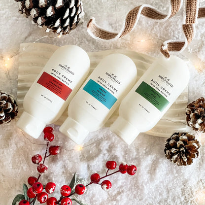 Simply Stated Winter Body Creme trio with shea butter, snowy holiday scene with pinecones and berries.