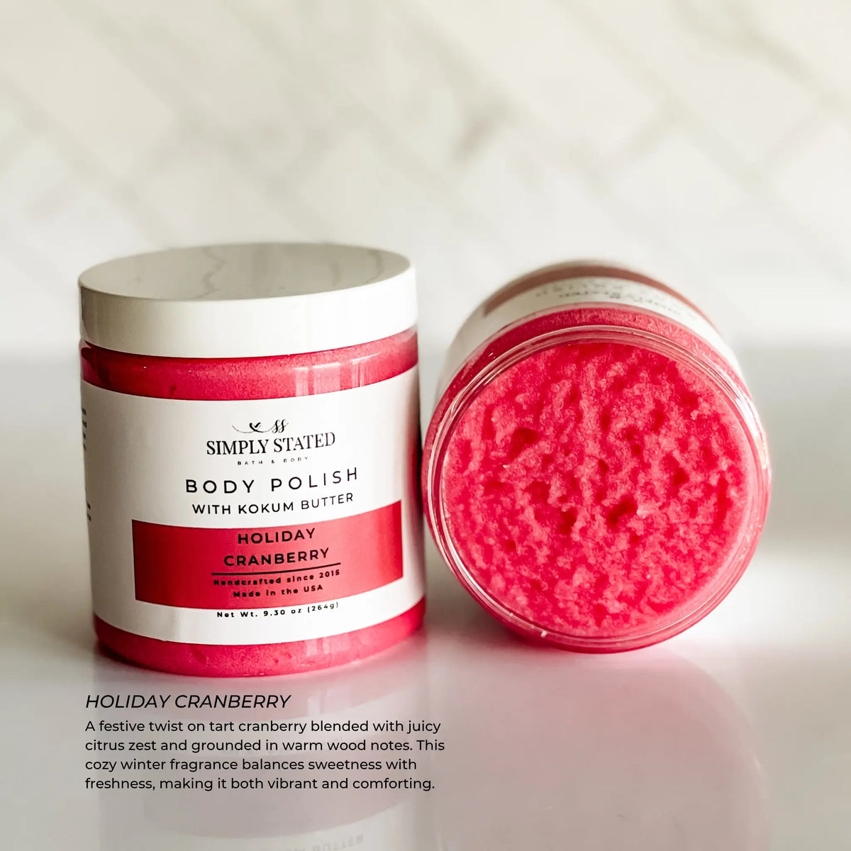 Simply Stated Holiday Cranberry Body Polish with kokum butter, tart cranberry citrus sugar scrub on marble.