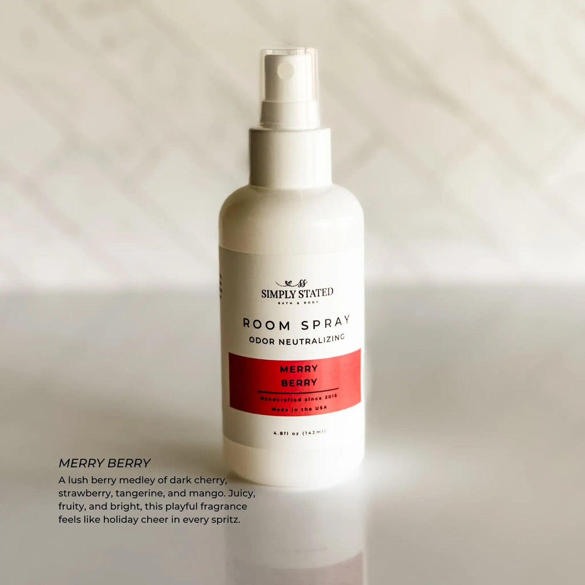 Simply Stated Merry Berry Room Spray, odor neutralizing, juicy cherry strawberry tangerine mango scent, on marble.