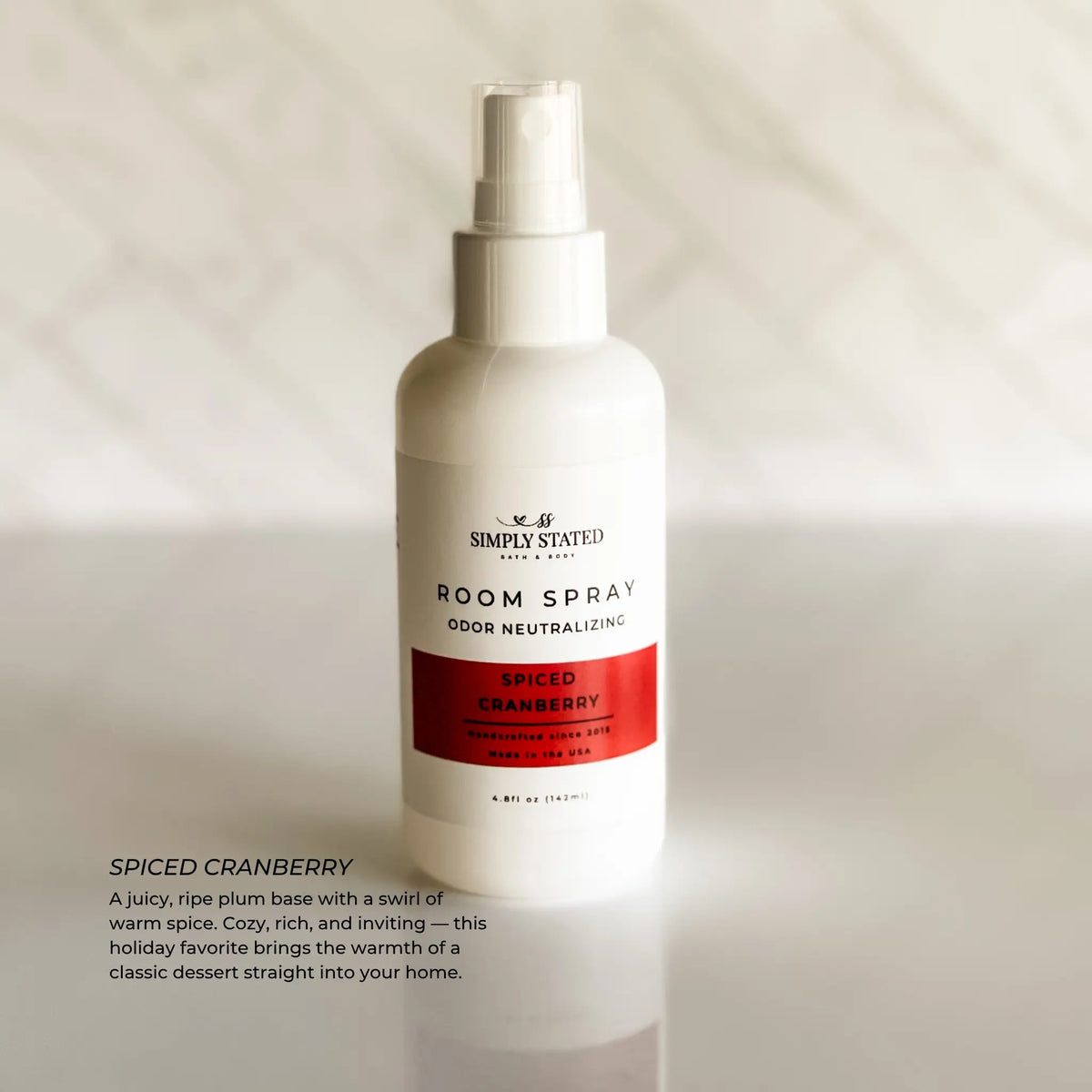 Simply Stated Spiced Cranberry Room Spray, odor neutralizing, juicy plum and warm spice scent, on marble.